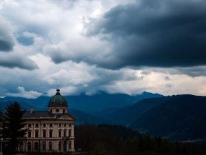 Peisaj românesc cu munți și cer furtunos.